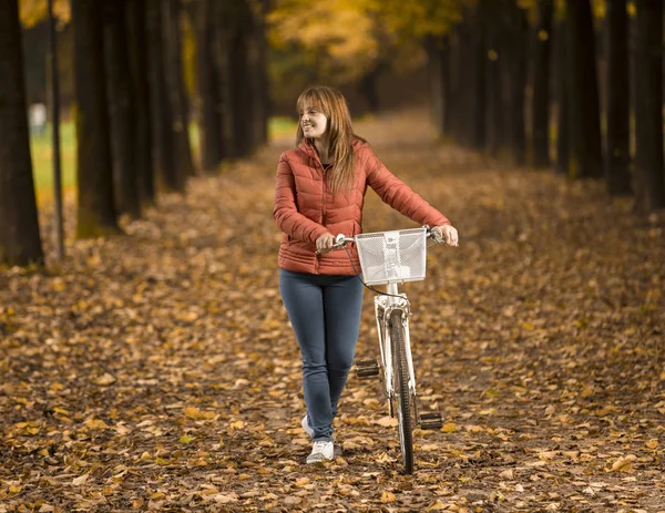 Femme à vélo dans le parc d'automne — Photo