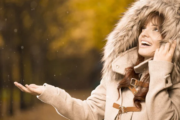 Žena v podzimní kabát kontrola pokud prší Stock Fotografie