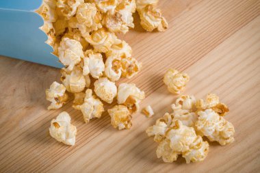 Ahşap masa üzerinde mavi karton kutu içinde patlamış mısır