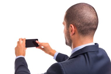 Yakışıklı işadamı arka bakmak beyaz bir arka plan üzerinde izole smartphone ile kendini bir selfie