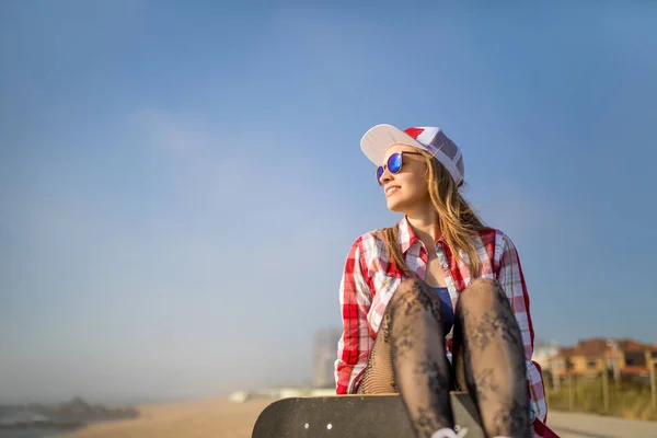 Schattig Meisje Zittend Met Skateboard Buurt Van Het Strand Zoek — Stockfoto