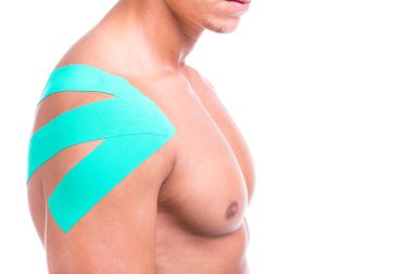 Adam beyaz bir arka plan üzerinde izole omuz kinesio bant ile