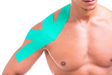 Bir adamın omzuna beyaz bir arka plan üzerinde izole kinesio bant ile yakın çekim