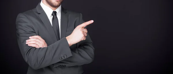 Geschäftsmann Zeigt Mit Dem Finger Auf Kopierraum Auf Schwarzem Hintergrund — Stockfoto
