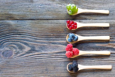 Tahta kaşık rustik ahşap bir masa üzerinde taze meyveleri