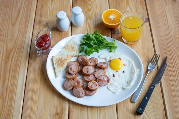 Portakal suyu, iki yumurta ve sosis sağlıklı kahvaltı için. — Stok fotoğraf