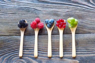 Tahta kaşık rustik ahşap bir masa üzerinde taze meyveleri