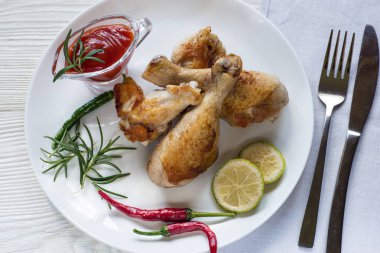 Rosemay ve kireç ile beyaz tabakta tavuk budu