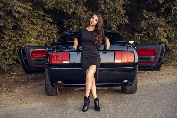 Belo cabelo marrom jovem mulher em vestido preto posando — Fotografia de Stock