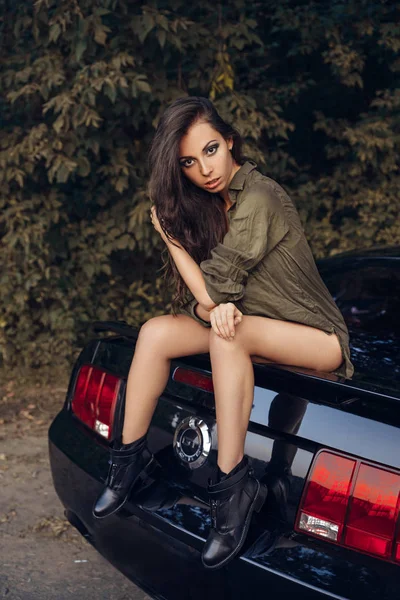 Sexy chica se muestra sentado en el coche — Foto de Stock