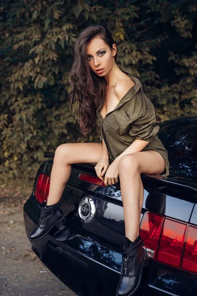 Сексуальная девушка сидит на машине — стоковое фото