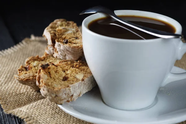 Xícara de café em fundo de madeira escura, com biscoitos cantucci — Fotografia de Stock