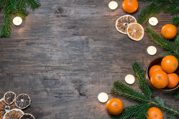 Tangerines on a dark wood background with Christmas tree — Stock Photo, Image