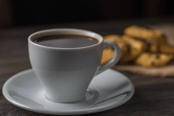 Кофейная чашка и печенье на деревенском деревянном фоне — стоковое фото