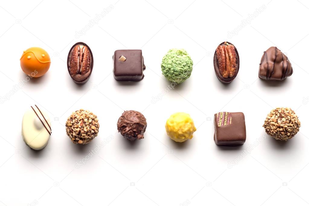 Various chocolate pralines isolated on white background. Top vie