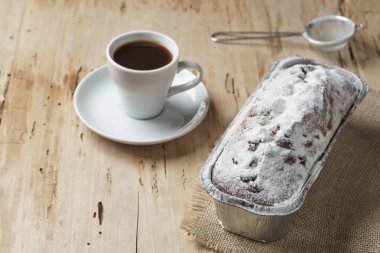 Kahve fincanı ve ahşap masa üzerine üzümlü kek