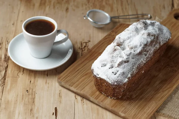 Koffiekopje en cake met rozijnen op houten bureau — Stockfoto