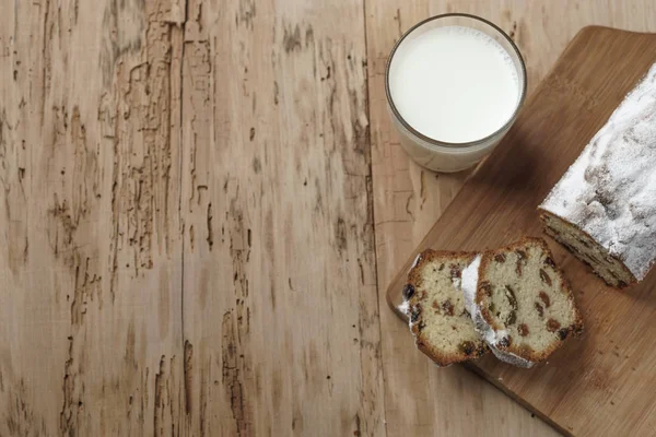 Szklankę mleka i ciasto z rodzynkami na biurko z drewna — Zdjęcie stockowe