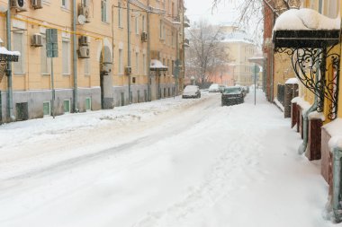 Yoğun kar yağışı şehir. Sokaklar, evler ve makine karlı.