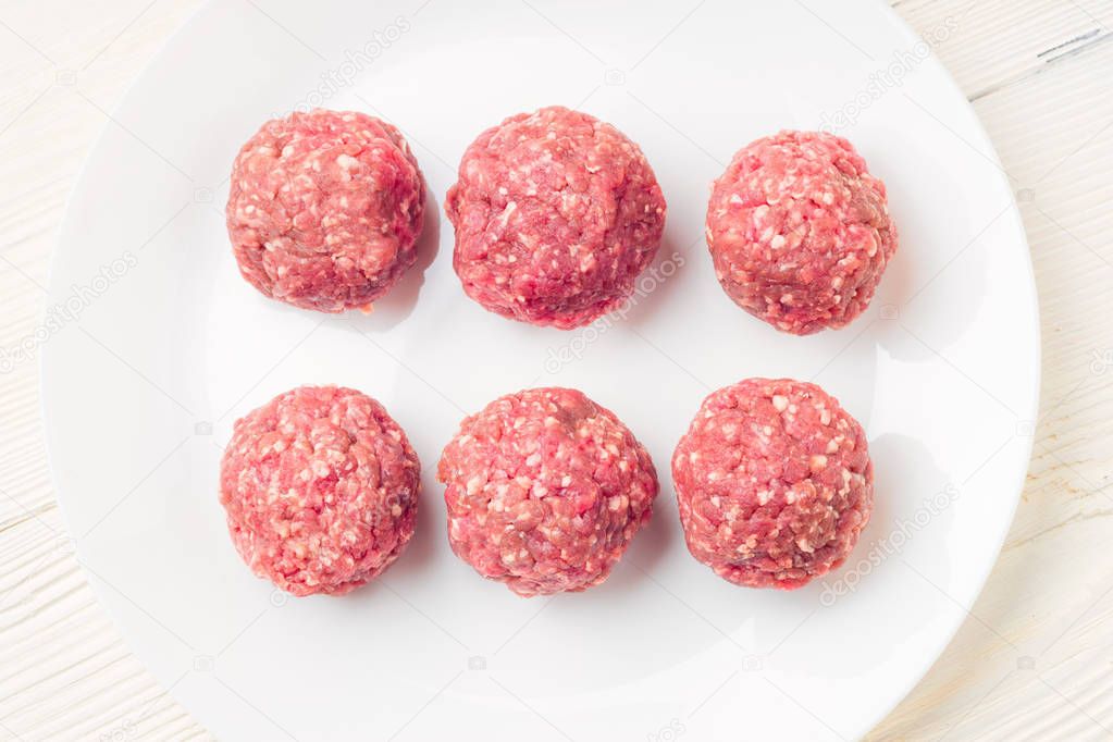 Meat balls from raw beef force-meat on a white plate