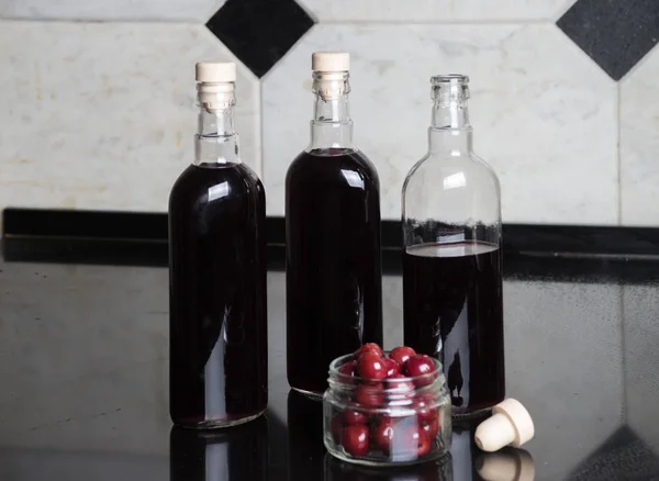 Tři lahve červeného vína třešeň — Stock fotografie