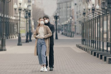 Boş sokaklar, koronavirüs, hastalık, enfeksiyon, karantina, tıbbi maske gibi arka planda birbirine aşık bir çiftin portresi.