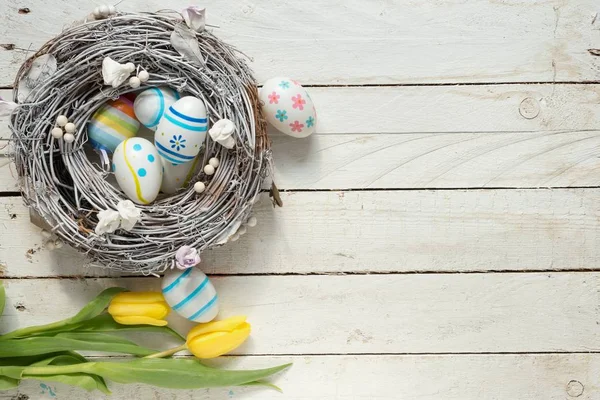 Huevos de Pascua y flores en la mesa — Foto de Stock