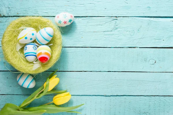 Paskalya yumurtaları ve masaya çiçek — Stok fotoğraf