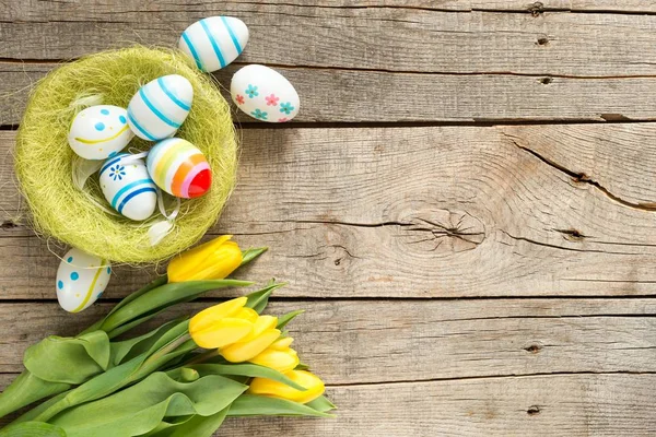 Easter eggs and flowers on table — Stock Photo, Image