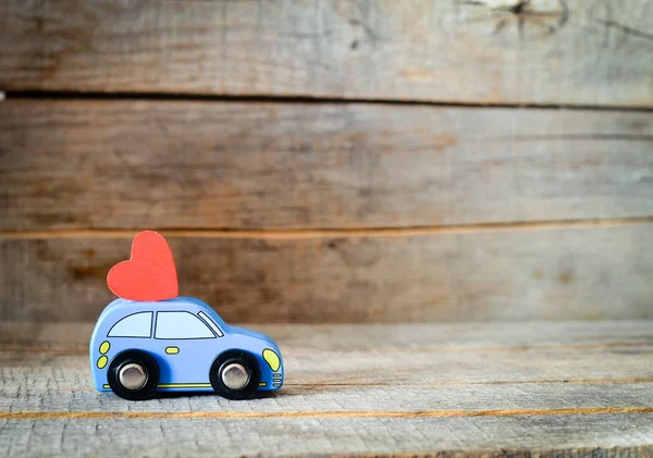 toy car delivering heart for Valentine\'s day on  background
