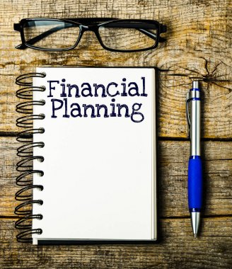 Ahşap arka plan üzerinde not defterinizdeki finansal planlama yazıt