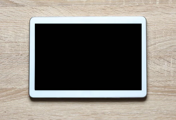 tablet pc with empty screen on wooden table