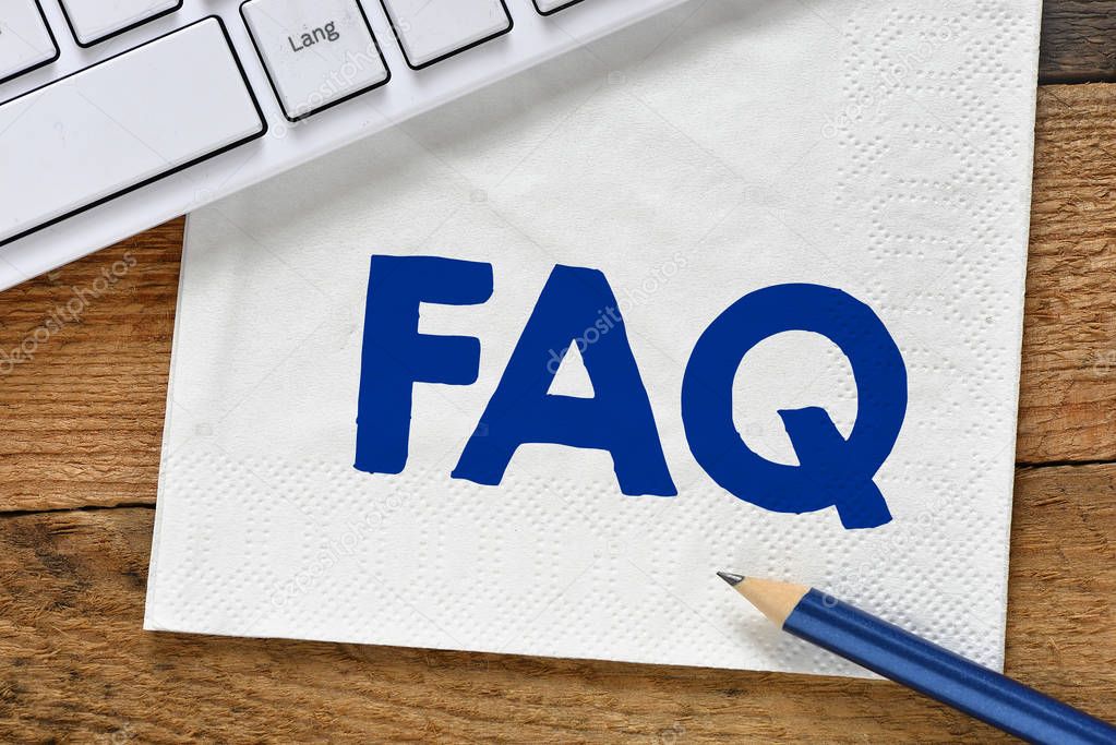 Text FAQ on white napkin near computer keyboard