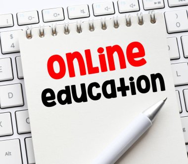 Bir bilgisayar klavyesinde bulunan bir defterde ONLINE EĞİTİM sözcüğü.