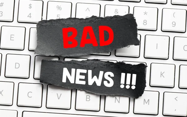 BAD NEWS word on small black pages placed on a computer keyboard.