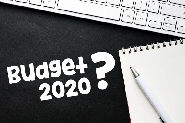 BUDGET 2020? text on black background in an office setting. Change of the budget for 2020. Business concept.