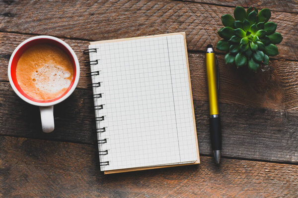 Пустой блокнот и кофейная чашка на рабочем столе