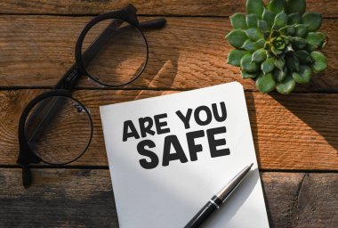 Defterde tahta bir masanın üzerine yazılmış güvenli bir kelime misin? Üst görünüm, konsept.