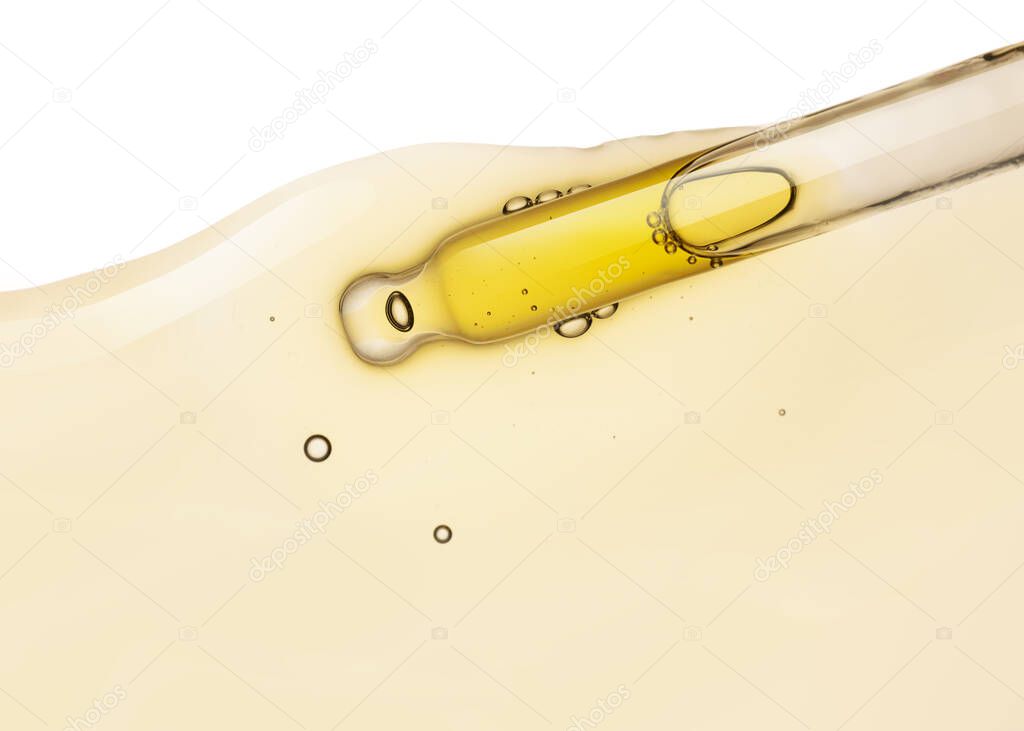 Liquid yellow gel or serum drop and pipette on white isolated background
