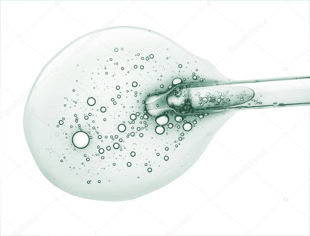 Liquid green gel or serum drop and pipette on white isolated background