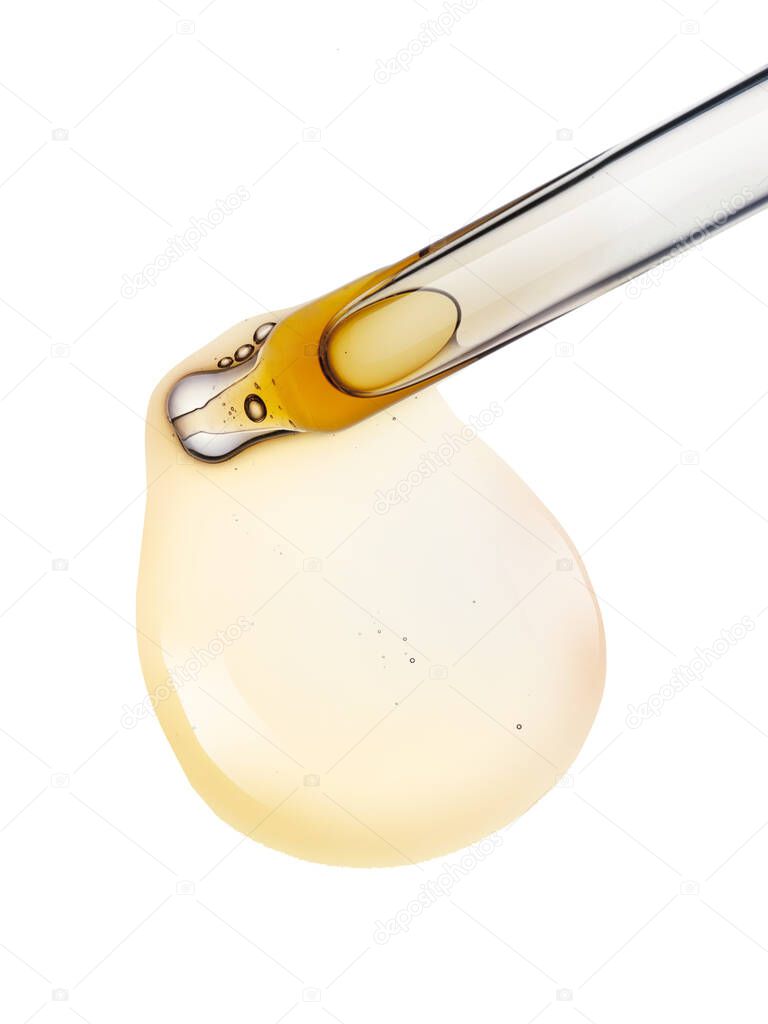 Liquid yellow gel or serum drop and pipette on white isolated background