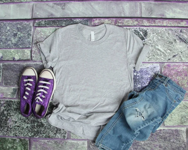 Сіра футболка макет плоский лежав на фіолетовому цегляному фоні з пурпуровим — стокове фото