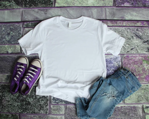 Bílé tričko maketa plochý ležela na fialové cihlové pozadí s pu — Stock fotografie