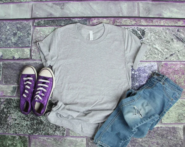 Grigio T Shirt mockup piatto laici su sfondo mattone viola con pur Fotografia Stock