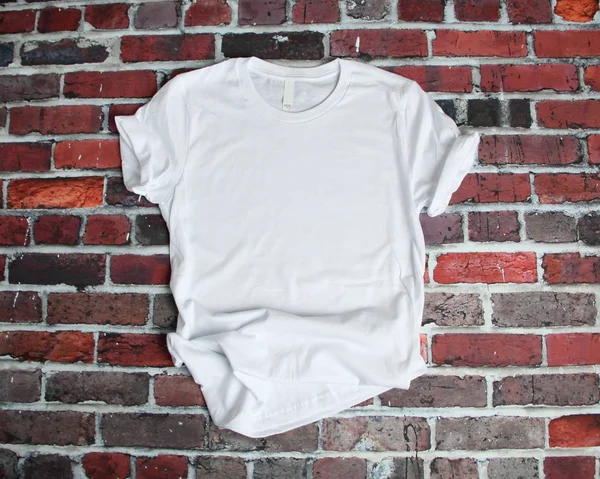Επίπεδη lay mockup του άσπρο μπλουζάκι σε φόντο τούβλο Φωτογραφία Αρχείου