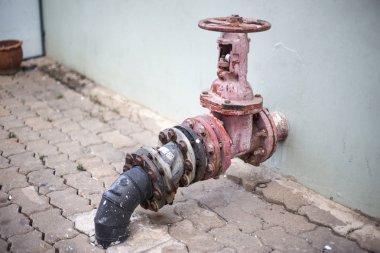 Eski siyah su boru birleştirme kırmızı valf ile bağlanmak underground için
