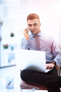 İş yerinde dizüstü bilgisayarda yazan başarılı genç işadamı