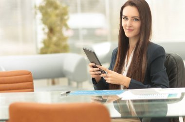 Genç iş kadını ofiste tablet ile çalışma