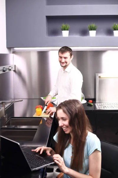 Portrait de heureux jeune couple cuisiner ensemble dans la cuisine. — Photo