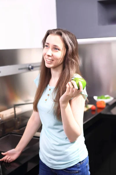 Joyeux jeune femme manger des pommes sur la cuisine — Photo